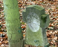 Betonowy krzyż (rustykowany) z widocznym odciskiem owalnej tablicy