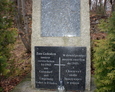 Kamienny postument pamiątkowy stojący zaraz przy wzniesieniu, na którym znajdował się cmentarz
