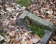 Pęknięta kamienna podstawa pod żeliwny krzyż
