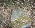 Przewrócony kamienny obelisk z niewidoczną inskrypcją