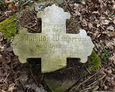 Widoczna inskrypcja na kamiennym krzyżu z dziecięcego nagrobka