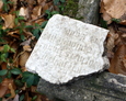 Niewielki fragment rozbitej płyty z cząstkowym fragmentem inskrypcji