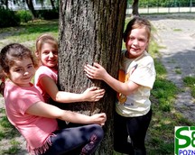 Uczniowie przytulają się do drzewa