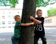 Uczniowie przytulają się do drzewa