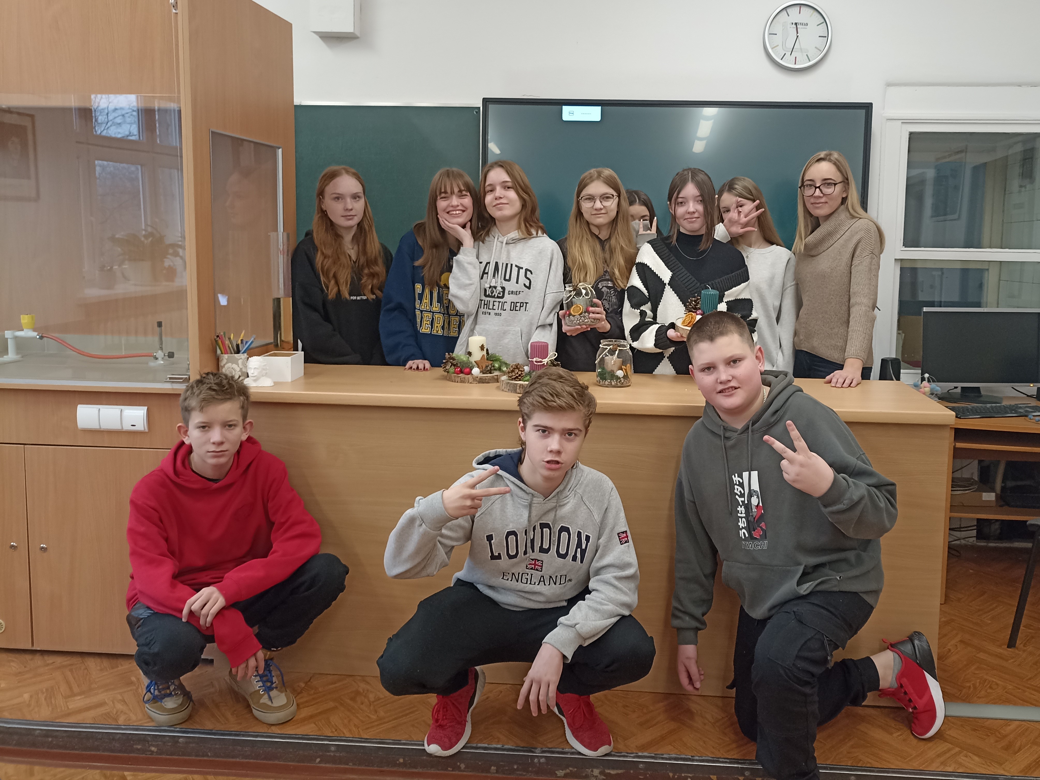 Wspólne zdjęcie uczniów wraz z nauczycielem, na stole stroiki świąteczne.